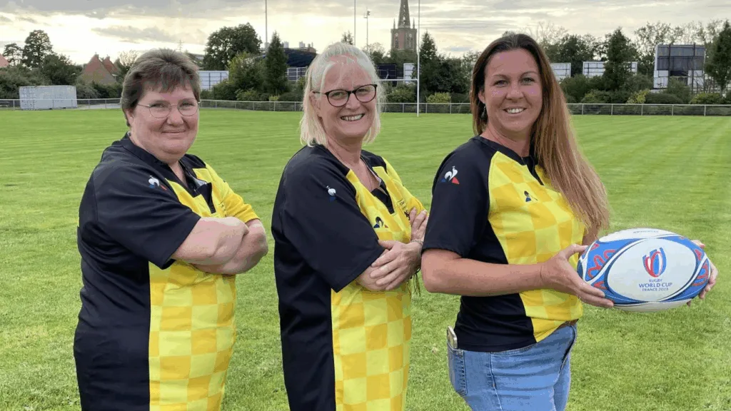 Три жінки у регбійних футболках на полі