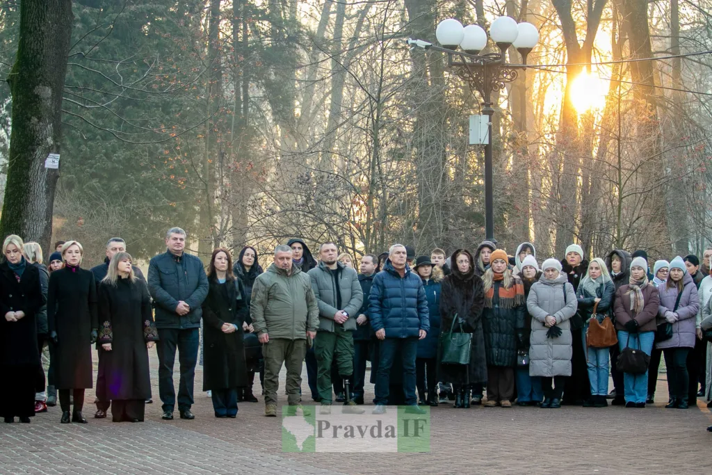 Люди стоять на заході в парку взимку