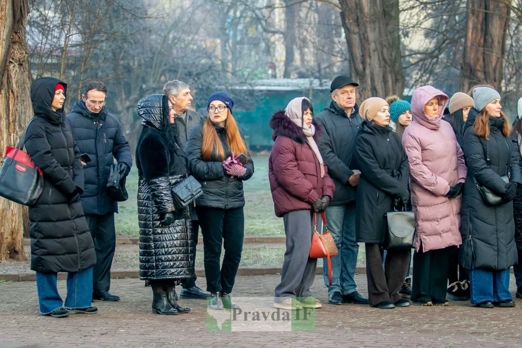 Люди стоять на вулиці в зимовому одязі