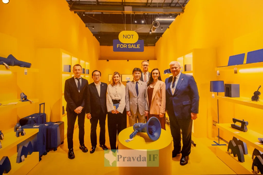 Група людей на виставці з жовтим оформленням