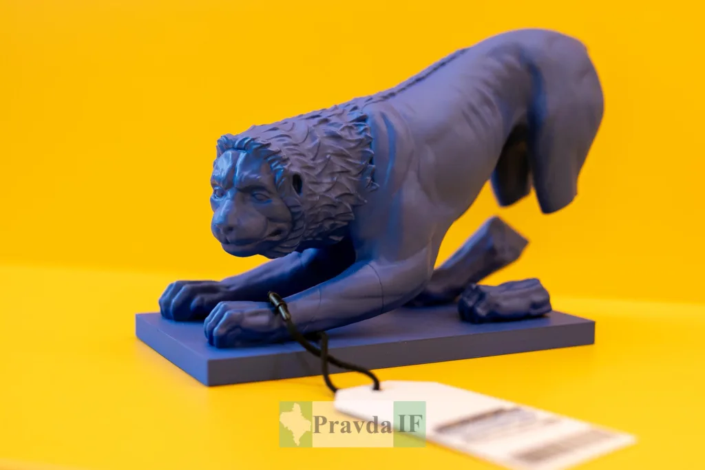 Синя статуетка лева на жовтому фоні