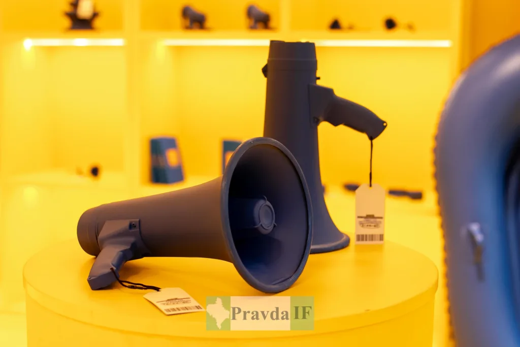 Сині мегафони на жовтому фоні виставки