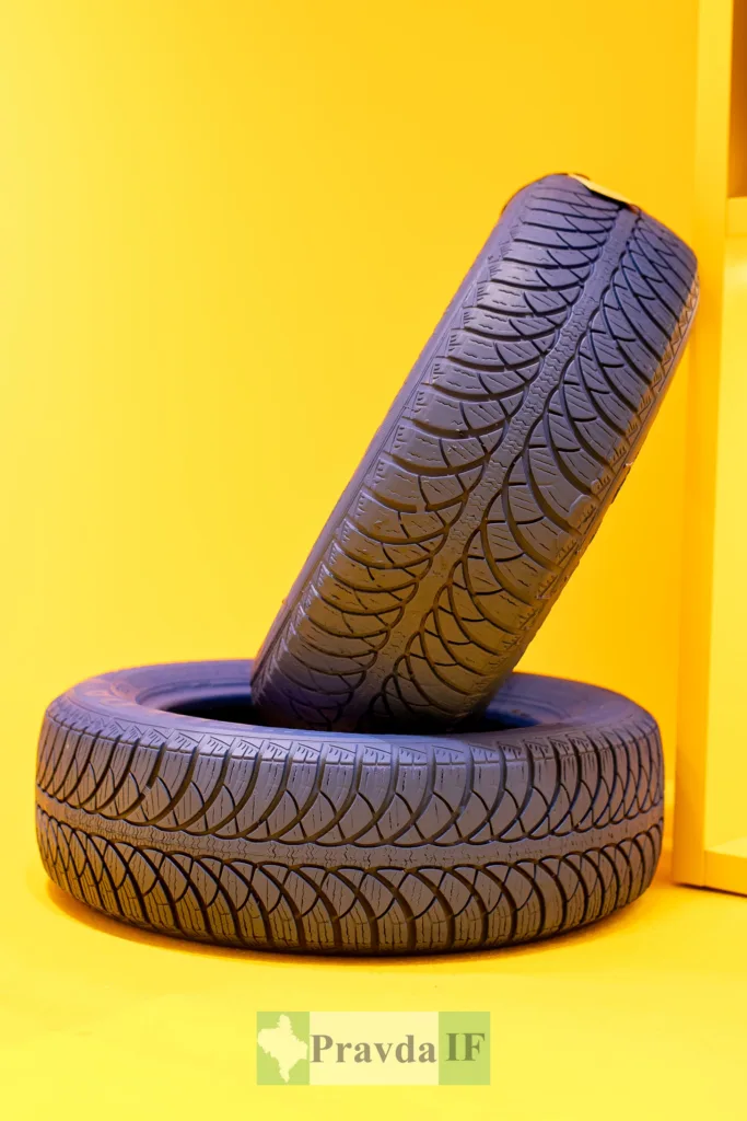 Дві чорні автомобільні шини на жовтому фоні