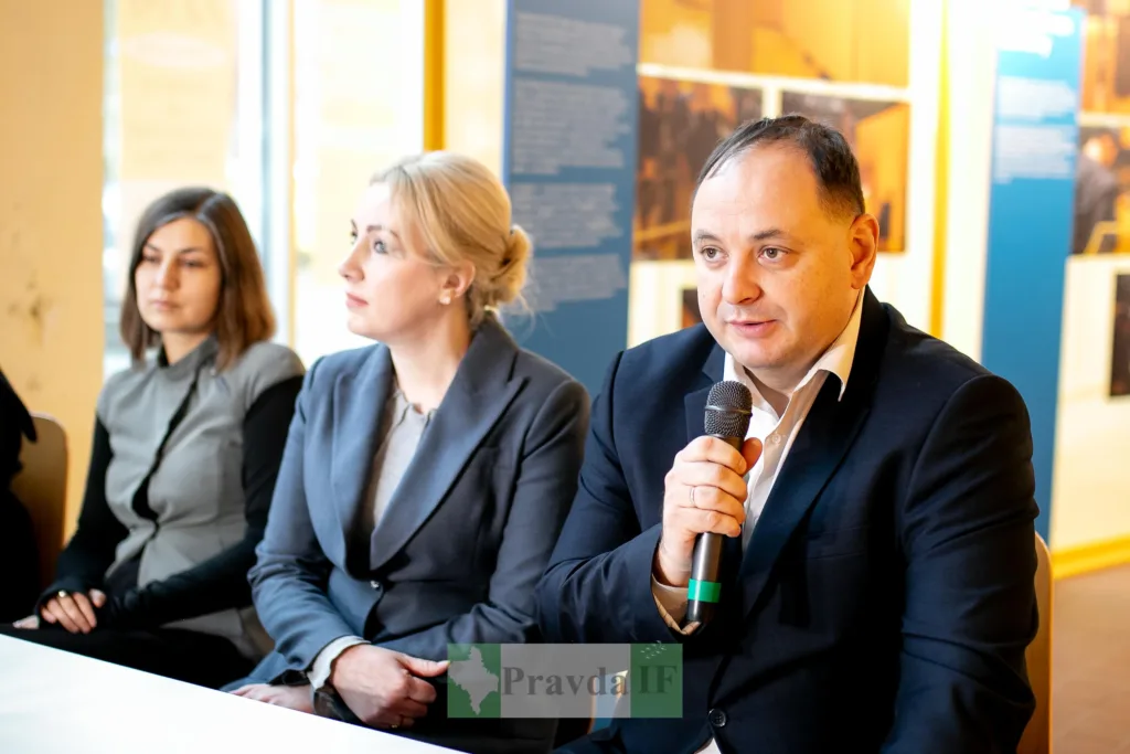 Чоловік виступає на пресконференції з мікрофоном