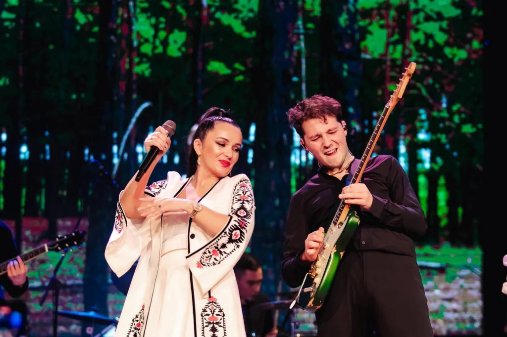 Співачка та гітарист виступають на сцені