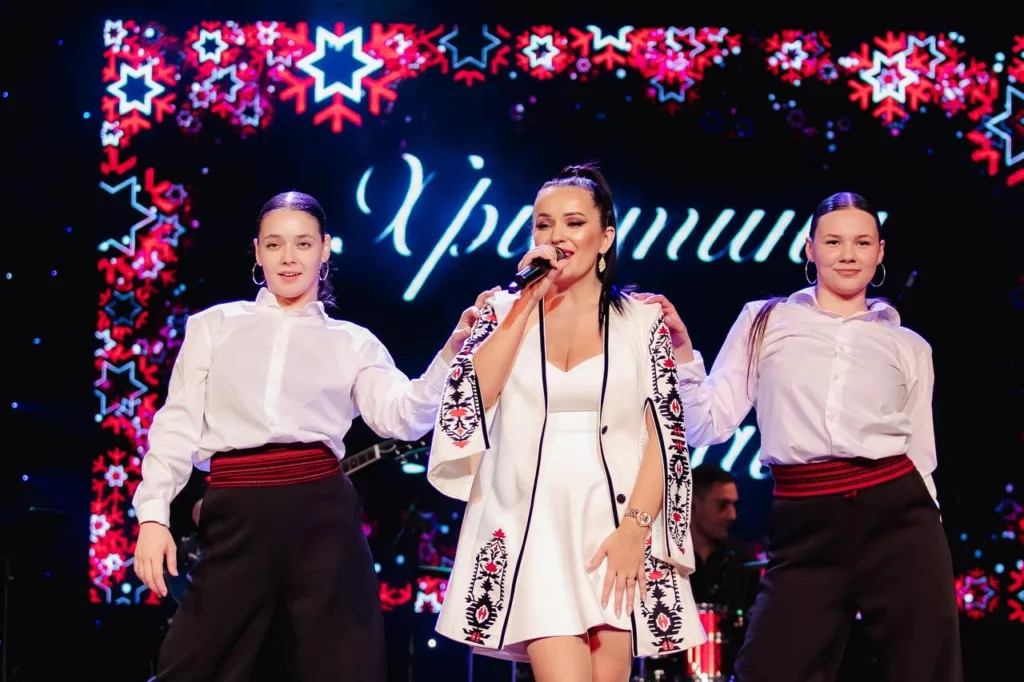 Співачка виступає на сцені з двома танцюристками