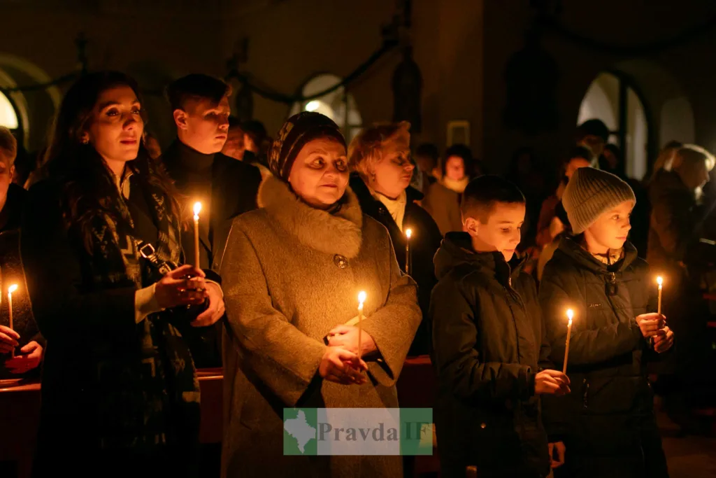 Люди тримають свічки під час церковної служби