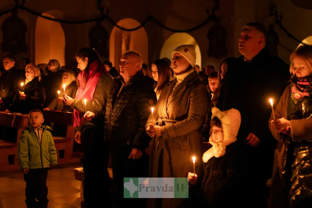 Люди з запаленими свічками під час богослужіння