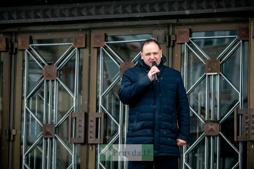 Чоловік говорить у мікрофон біля будівлі