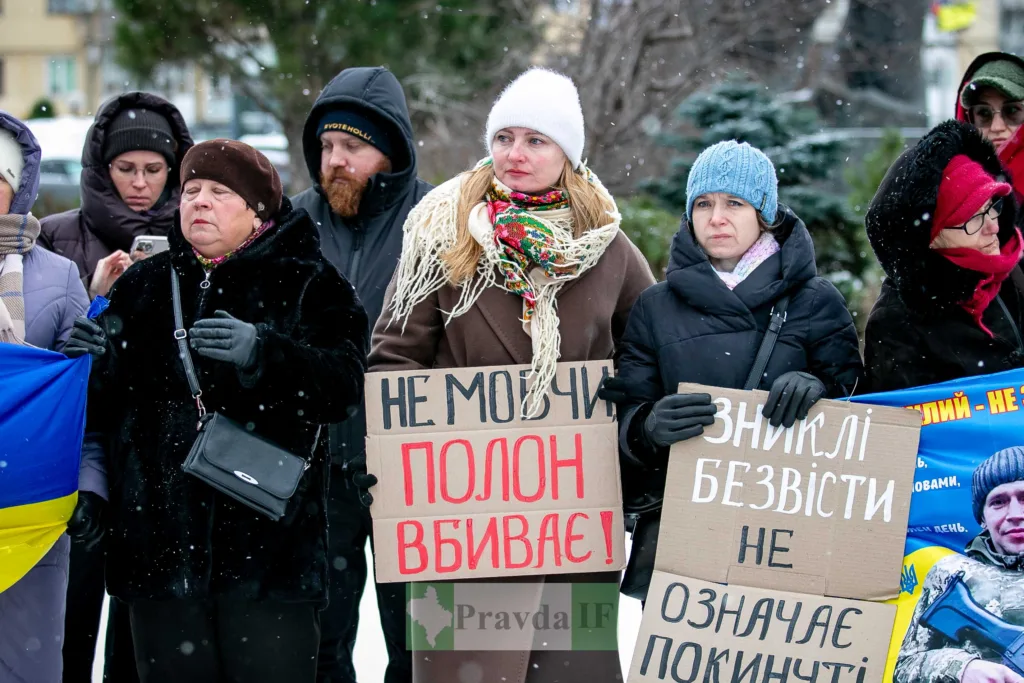 Протест у зимовому місті з плакатами та прапором України