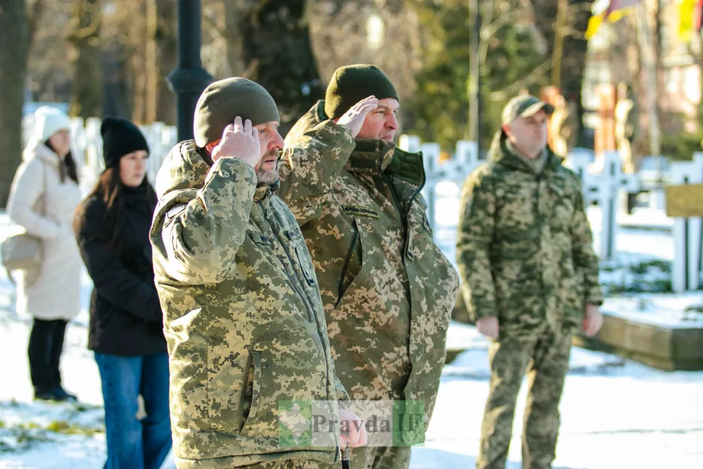 Військові віддають честь на цвинтарі взимку