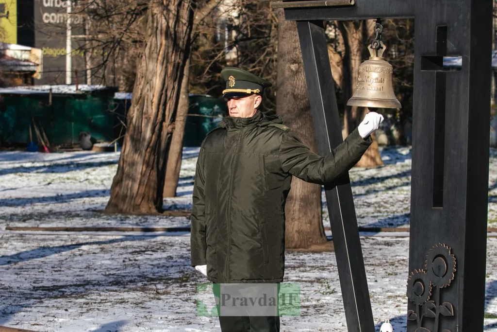 Військовий біля дзвону пам'яті взимку