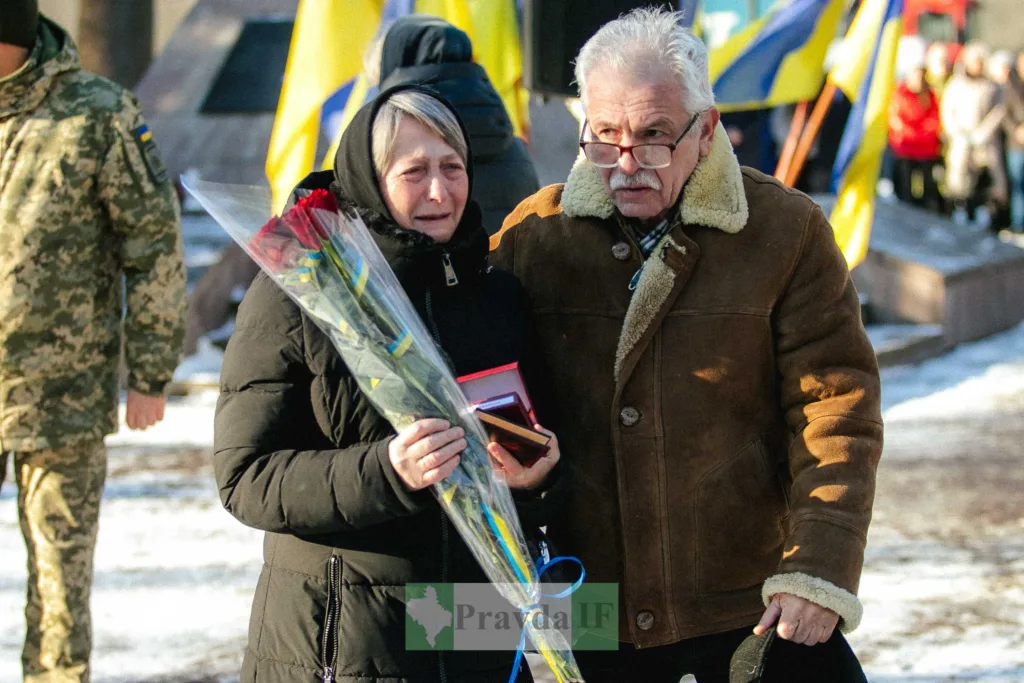 Сумні люди з квітами на церемонії пам’яті