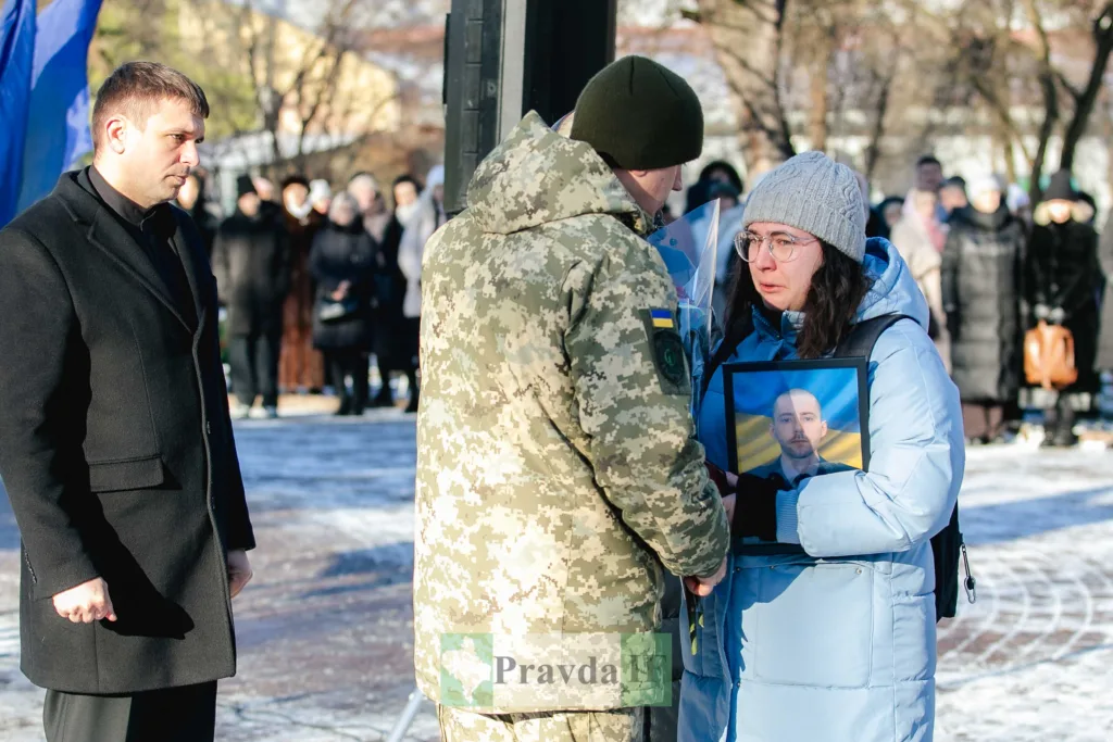 Жінка отримує співчуття від військового на церемонії