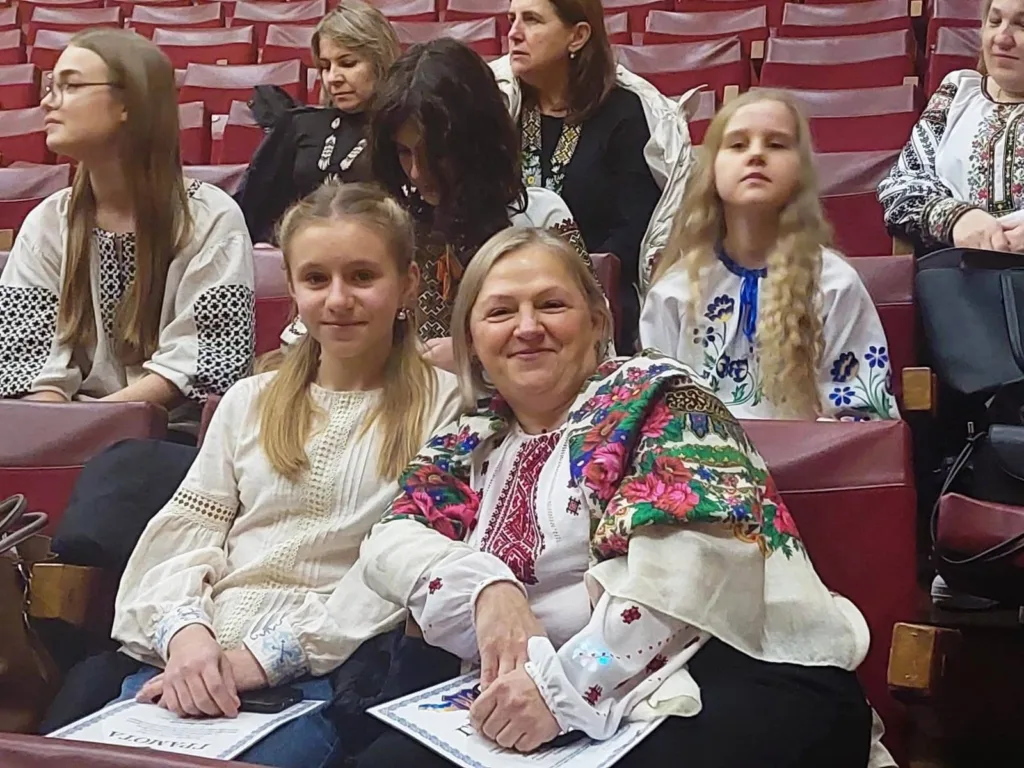 Люди у вишиванках сидять у залі