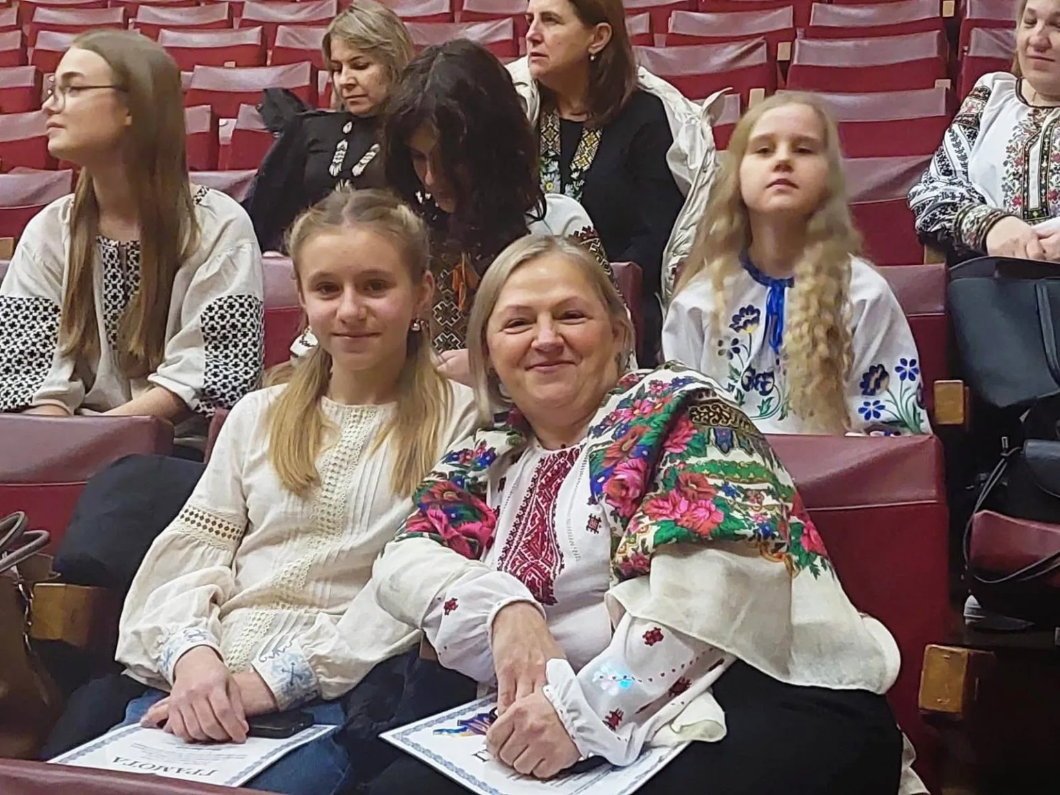 Люди у вишиванках сидять у залі