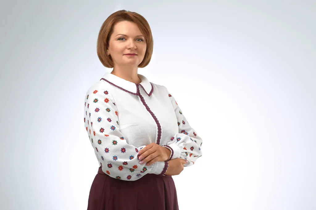 Жінка у вишиванці позує на світлому фоні