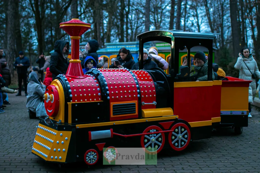 Дитячий поїзд у парку з пасажирами