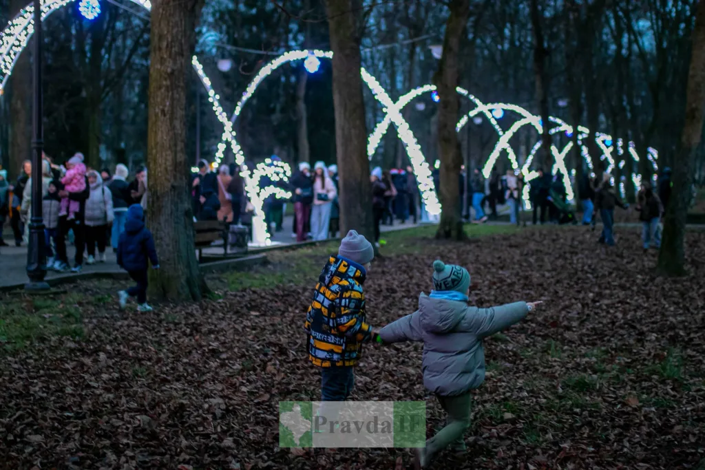 Діти граються в парку серед новорічних вогнів