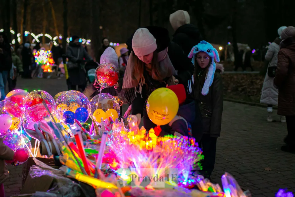 Діти біля яскравих світлових куль у парку