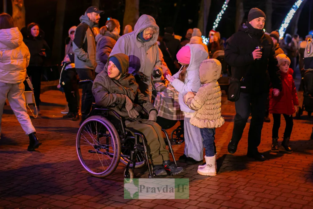 Люди на зимовому святі у вечірньому парку