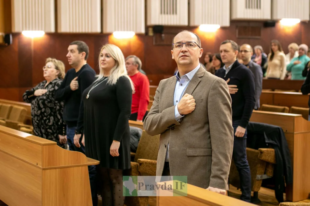 Люди стоять у залі з руками на серці