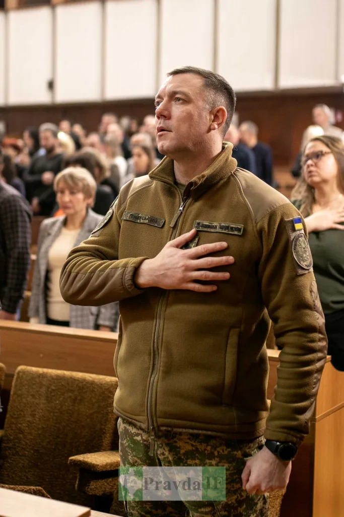 Військовий стоїть із рукою на серці в залі