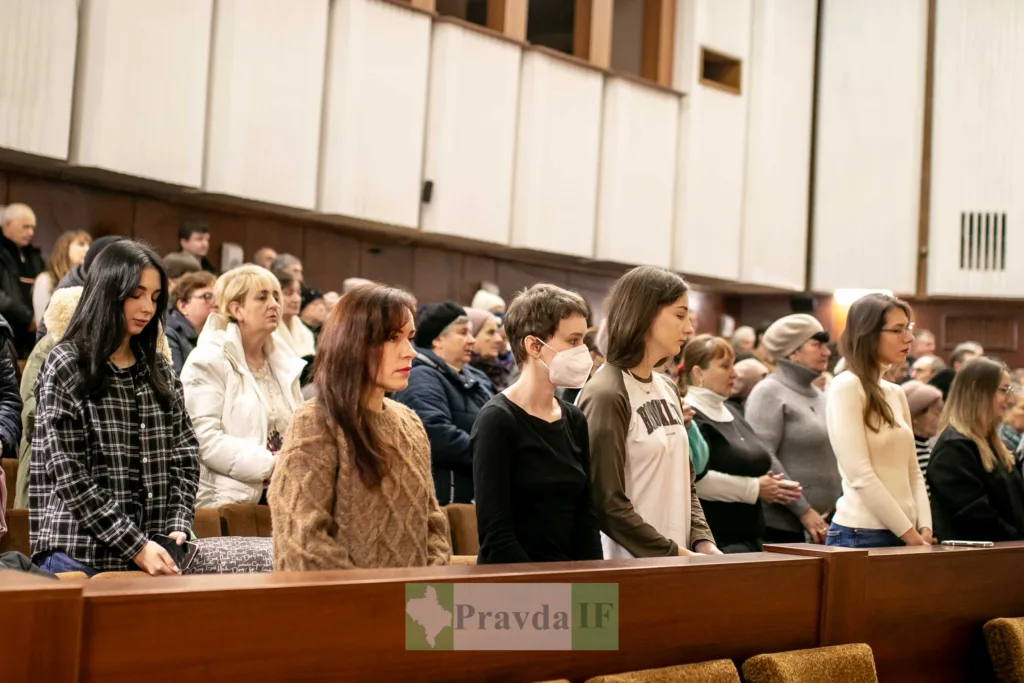 Люди стоять у залі під час заходу