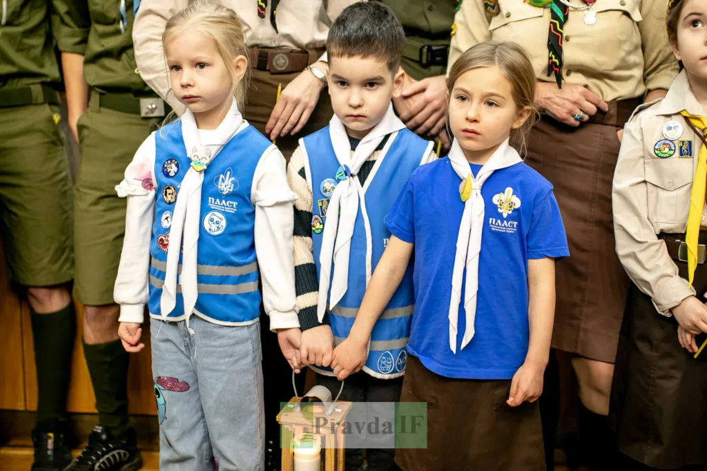 Діти пластуни тримають Вифлеємський вогонь миру