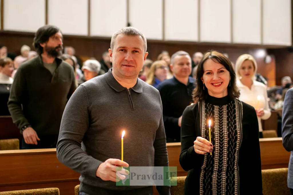 Люди тримають свічки під час церковної служби