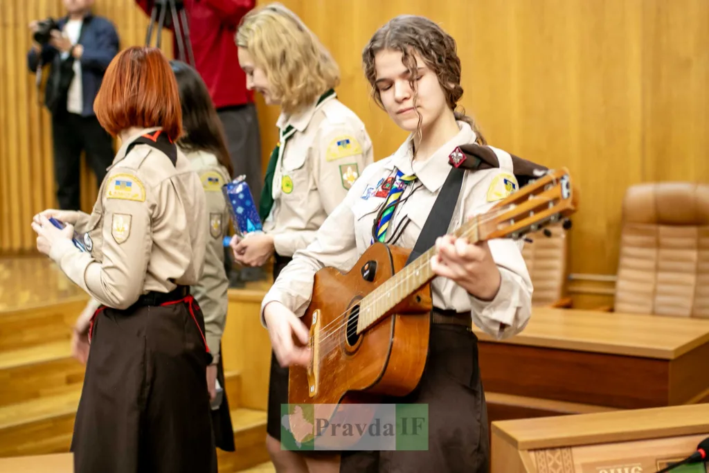 Українські скаути грають на гітарі під час заходу