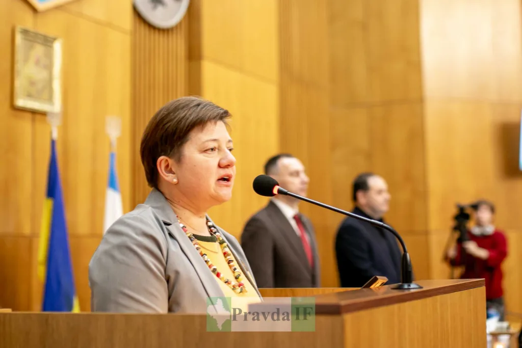 Жінка виступає на трибуні у залі засідань