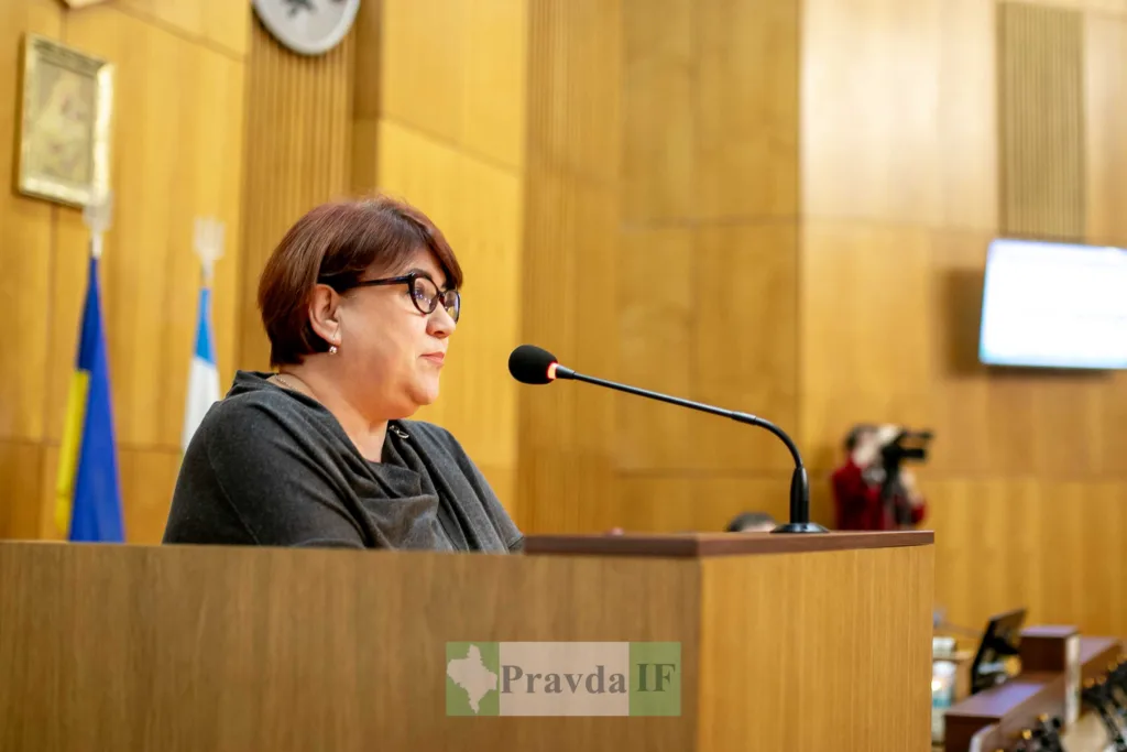 Жінка виступає на трибуні у залі засідань