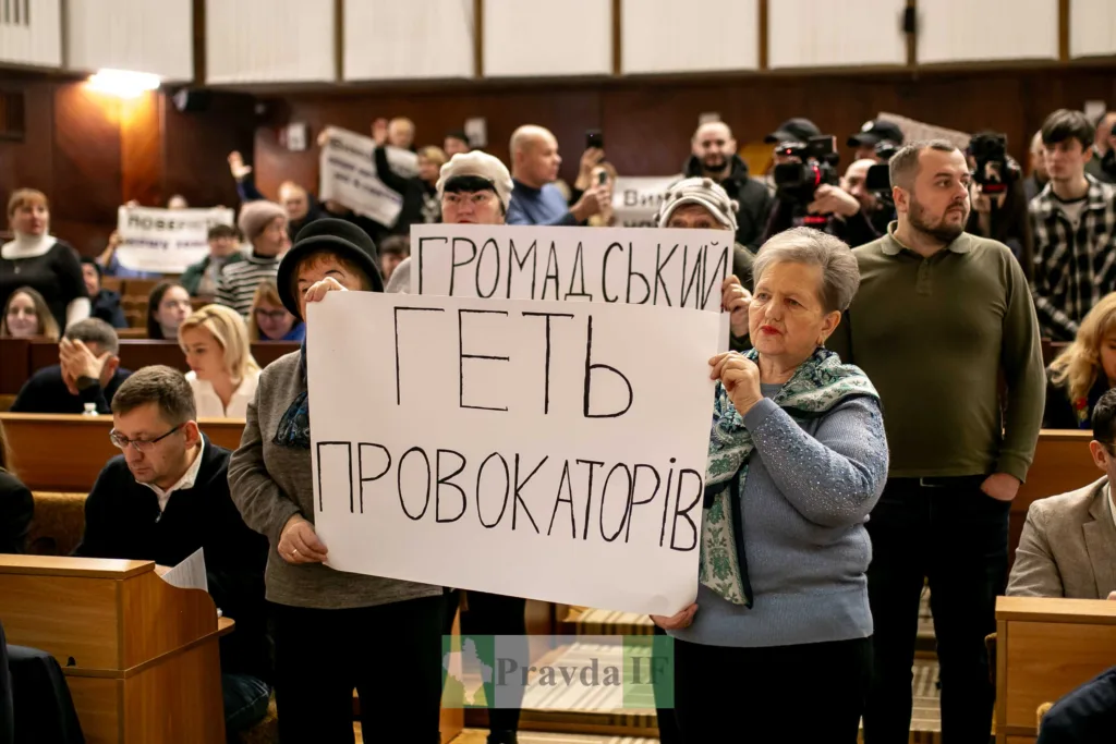 Люди тримають плакати на громадських зборах