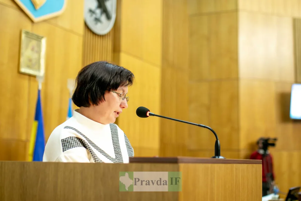 Жінка виступає на трибуні в залі засідань