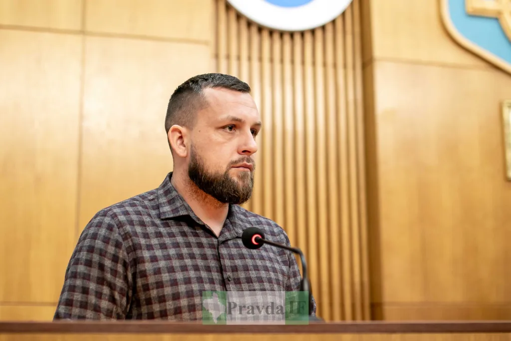 Чоловік виступає на трибуні в залі засідань