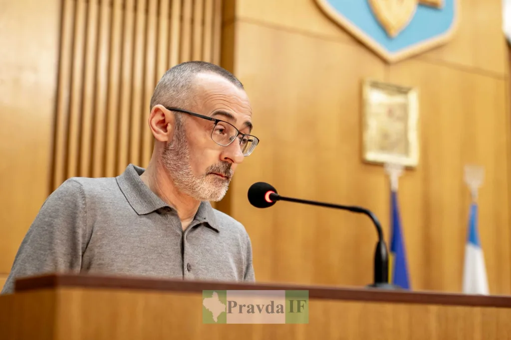 Чоловік виступає на конференції за кафедрою