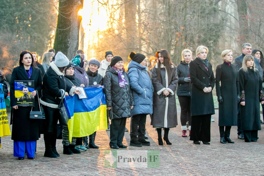 Люди з українським прапором на вуличному заході