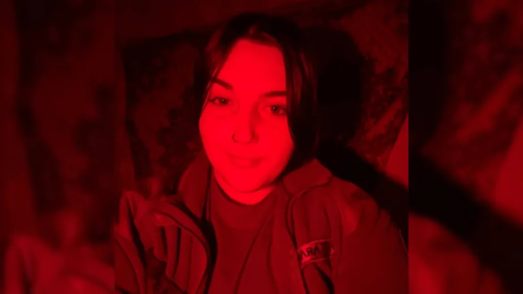 Людина у червоному освітленні робить селфі