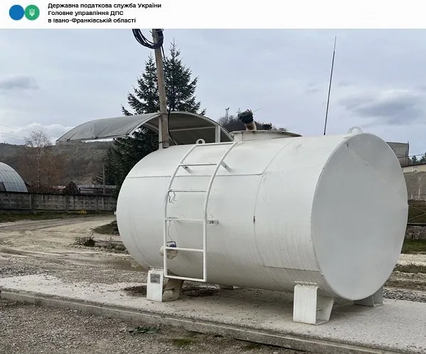 Велика біла металева цистерна на відкритому майданчику