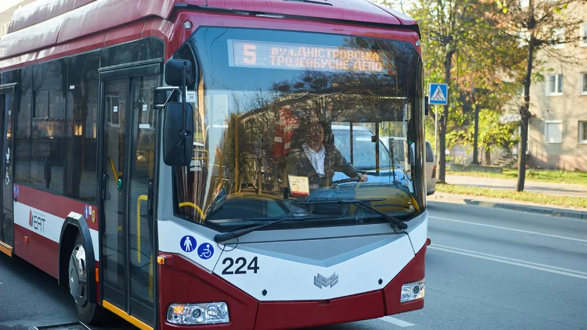 Сучасний червоно-білий тролейбус на міській вулиці