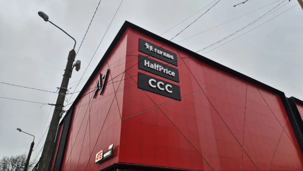 Червона будівля торгового центру з вивісками магазинів