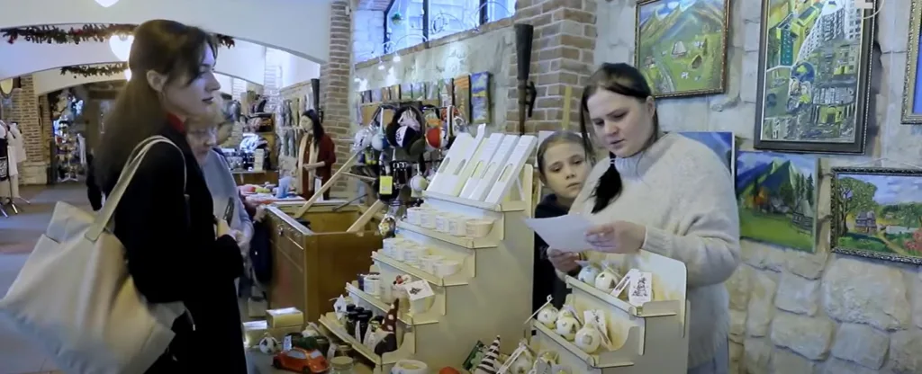 Люди купують сувеніри в художньому магазині
