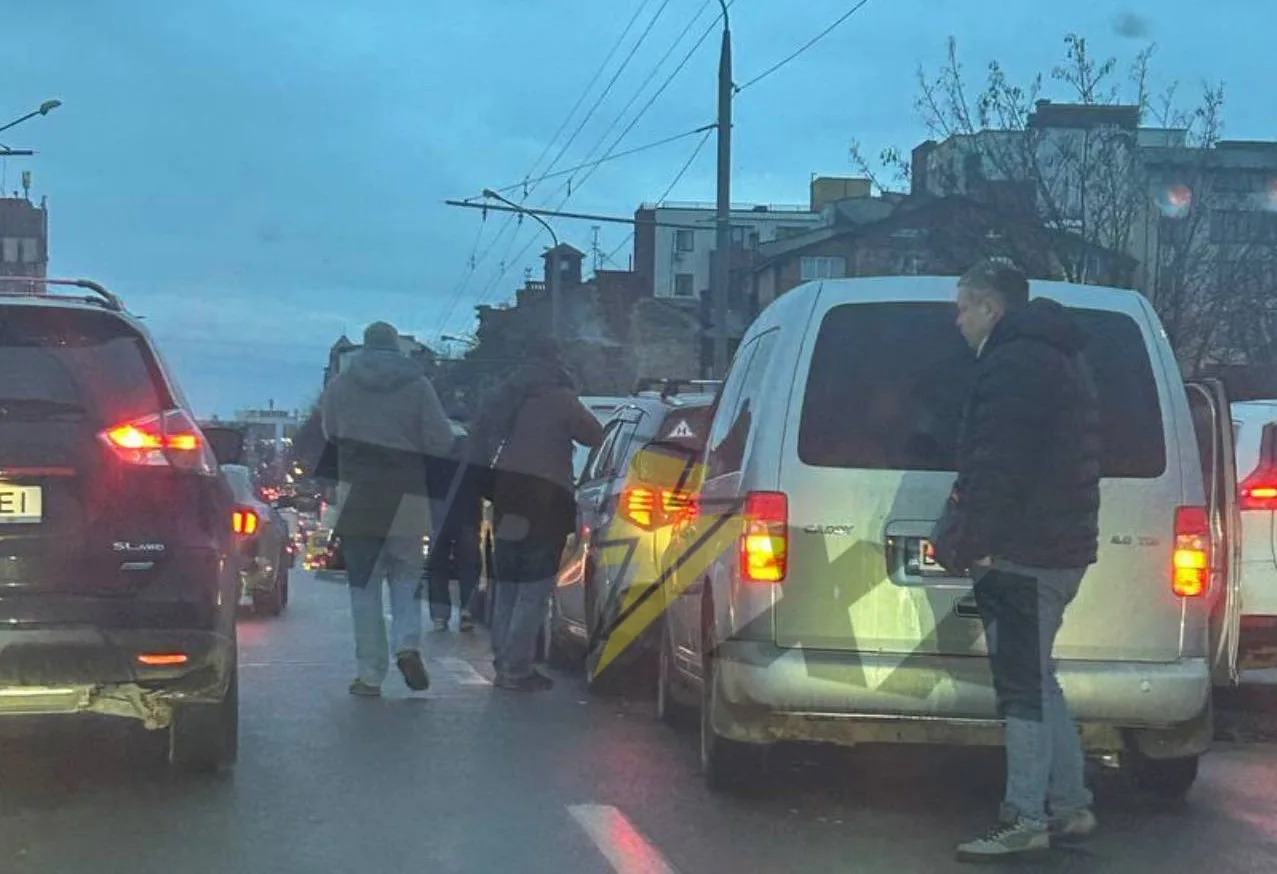 Люди штовхають автомобіль на міській дорозі