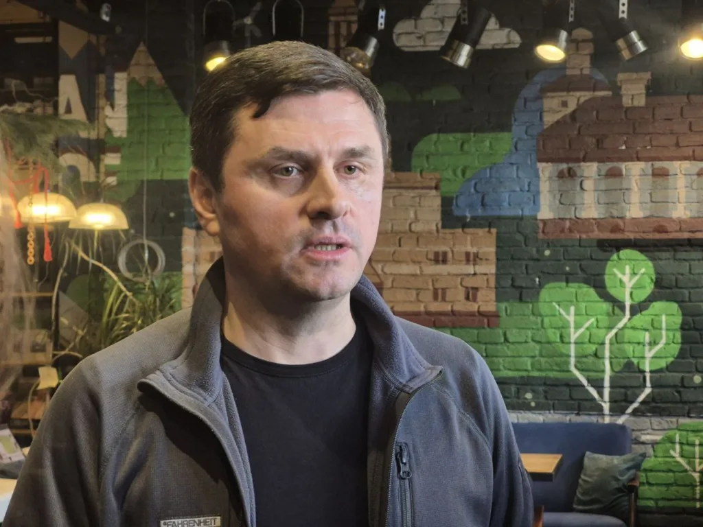 Чоловік у кафе на тлі настінного мистецтва