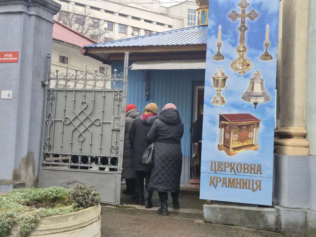 Люди заходять до церковної крамниці біля храму