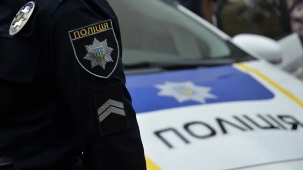 Поліцейський біля службового автомобіля поліції України