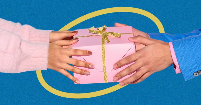 Дві руки обмінюються рожевим подарунком із стрічкою
