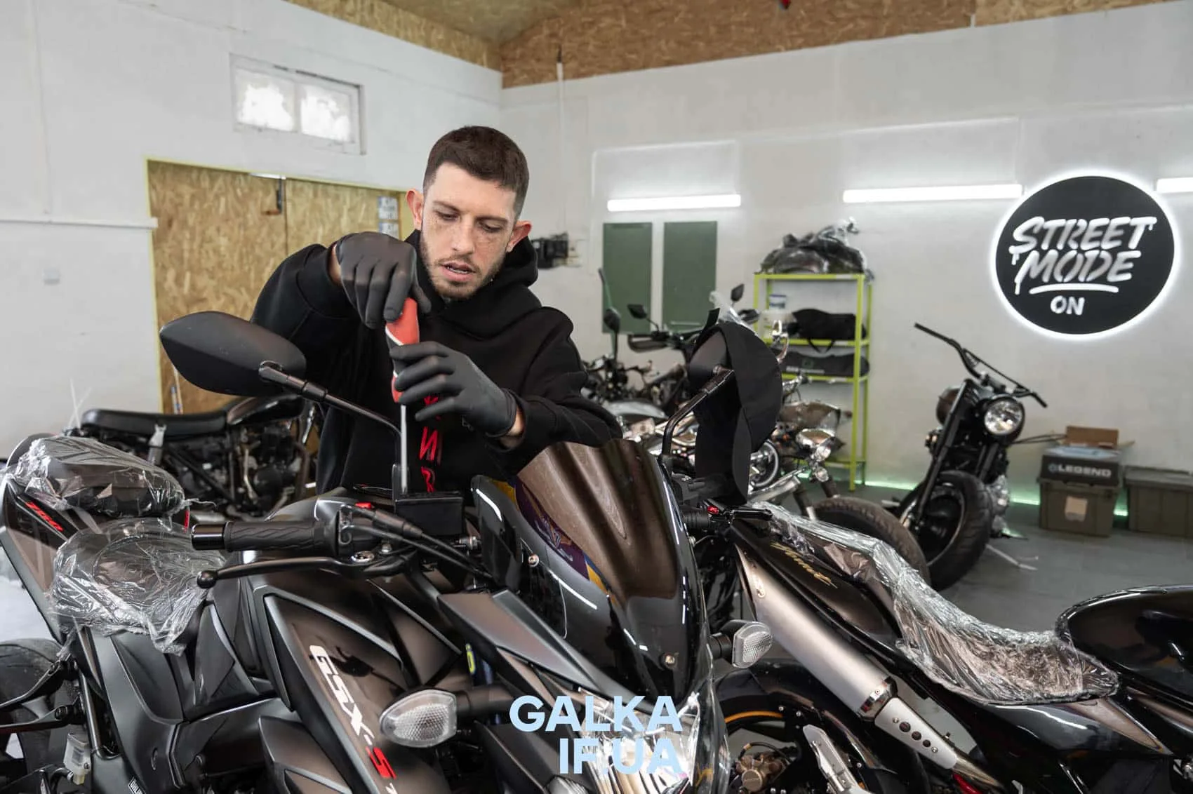 Механік ремонтує мотоцикл у майстерні