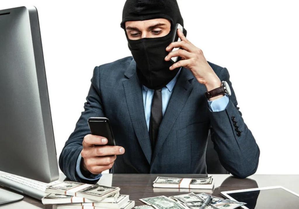 Людина в масці з грошима та телефонами